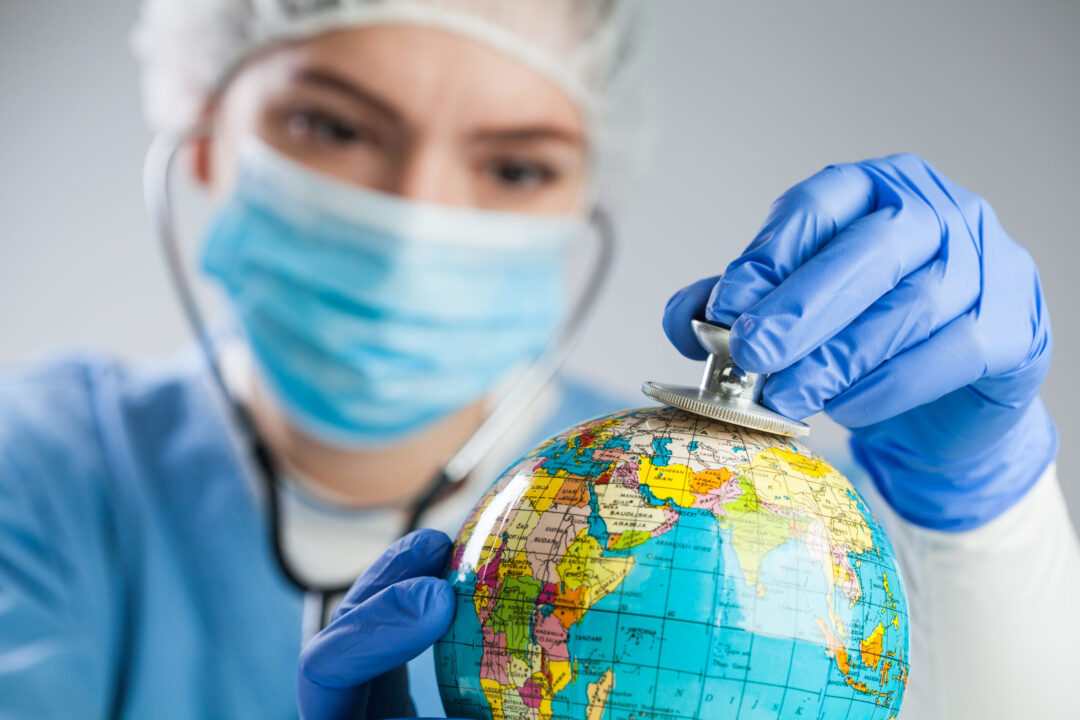 Doctor using a stethoscope to listen to the planet Earth globe a